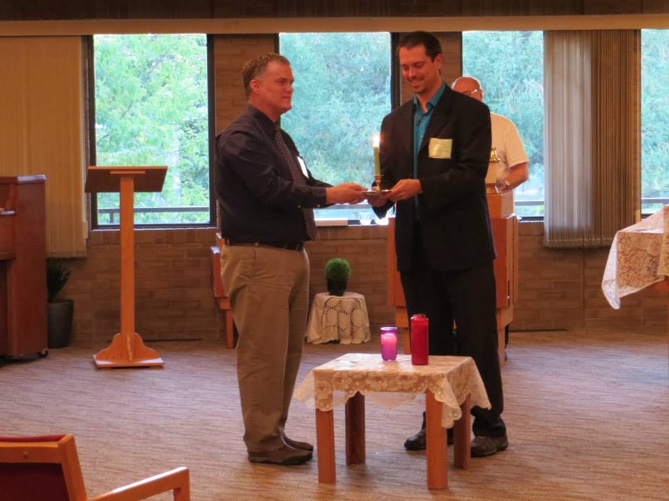 Darren Dahl and Norman Levesque passing the candle from the Prairie Centre for Ecumenism to the Canadian Centre for Ecumenism, hosts of the 2018 Forum on Inter-Church Dialogues. Photo by André Lavergne, ELCIC